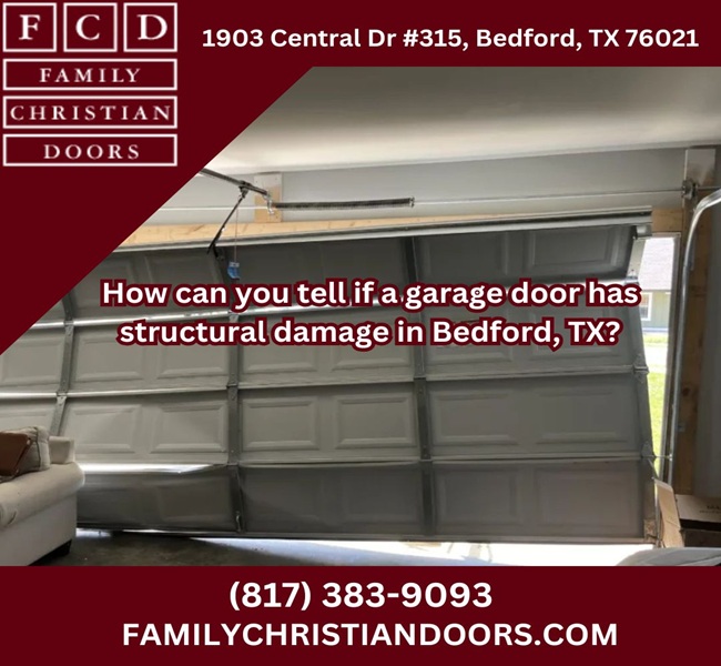 Damaged garage door with repair company advertisement