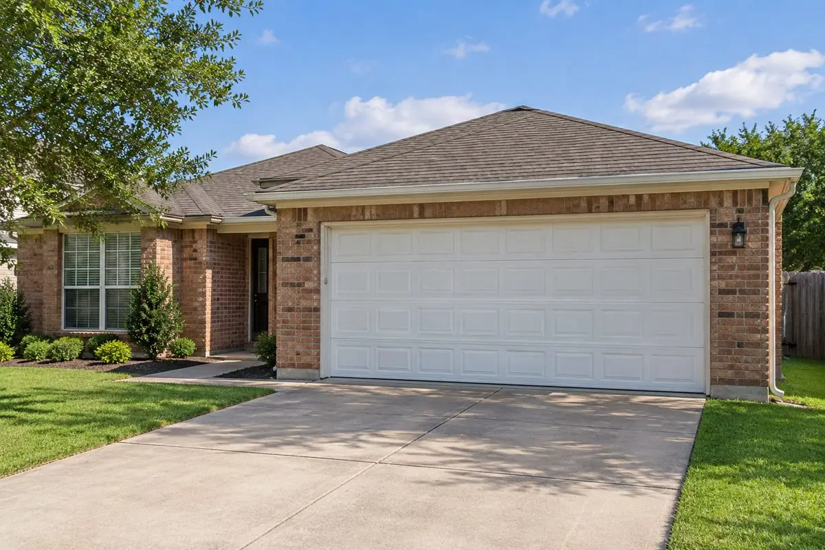 White residential double garage door on a modest Dallas-style brick home